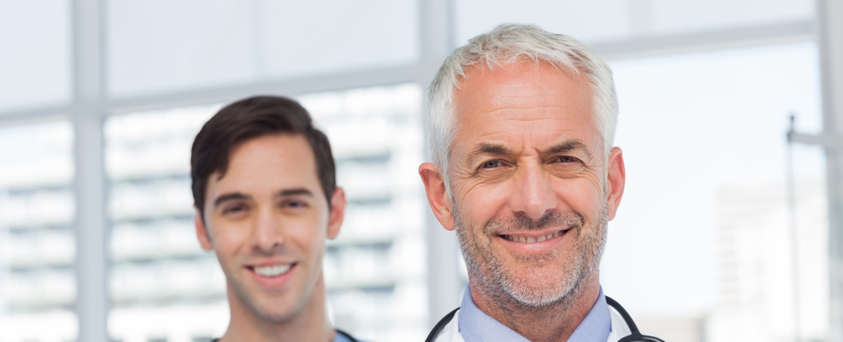 50s, Mature Adult, Man, Male, Caucasian, 20s, Young Adult, Indoors, Looking At Camera, Doctor, Practitioner, Profession, Professional, Specialist, Lab Coat, Stethoscope, Confident, Nurse, Scrubs, Blue, Standing, Clinic, Healthcare, Hospital, Medical, Staff, Attractive, Handsome, Grey Hair, Portrait, Team, Smiling, Happy, Cheerful, Friendly